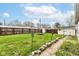 Large backyard featuring lush green grass, a fire pit, privacy fence, shed and rock garden at 590 N 17Th St, Noblesville, IN 46060