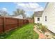 Landscaped backyard featuring a brick path, lawn, fence and garden at 590 N 17Th St, Noblesville, IN 46060