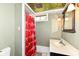 Cozy bathroom features patterned ceiling, sink, vanity, and a unique Ohio State themed shower curtain at 590 N 17Th St, Noblesville, IN 46060