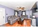 Inviting living room features hardwood floors, a ceiling fan, a stone fireplace, and ample seating at 590 N 17Th St, Noblesville, IN 46060