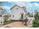 Spacious backyard featuring an outdoor dining set, barbecue grill, stone patio, manicured lawn, and a two-story house at 5942 Primrose Ave, Indianapolis, IN 46220