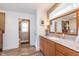 Bathroom boasts a wood vanity, granite countertops, decorative mirror and an ensuite toilet room at 5942 Primrose Ave, Indianapolis, IN 46220