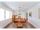 Elegant dining room featuring a modern chandelier, hardwood floors, and ample natural light at 5942 Primrose Ave, Indianapolis, IN 46220