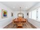 Bright dining room boasts a stylish chandelier, natural light, and hardwood floors, perfect for gatherings at 5942 Primrose Ave, Indianapolis, IN 46220