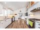 This well-lit kitchen features white cabinetry, stainless appliances, bar seating and hardwood floors at 5942 Primrose Ave, Indianapolis, IN 46220