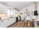 Bright kitchen featuring stainless appliances, white cabinetry, hardwood floors and bar stool seating at 5942 Primrose Ave, Indianapolis, IN 46220