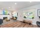 Open-concept living room with a cozy fireplace, hardwood floors, and large windows for ample natural light at 5942 Primrose Ave, Indianapolis, IN 46220