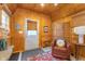 Charming shed interior with wooden walls, white door, accent chair, wood-look flooring, and decor at 5942 Primrose Ave, Indianapolis, IN 46220