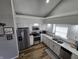Bright kitchen with stainless steel appliances, wooden floors, and gray countertops at 599 Cielo Vista Dr, Greenwood, IN 46143