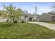 Landscaped front yard with blooming trees and a charming brick facade at 6846 Emerald Bay Ln, Indianapolis, IN 46237