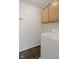 Bright laundry room features a washing machine, overhead cabinets, utility hook, and wood-look flooring at 6846 Emerald Bay Ln, Indianapolis, IN 46237