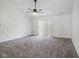 Bright living room featuring neutral carpet, ceiling fan, and sliding glass door with ample natural light at 6846 Emerald Bay Ln, Indianapolis, IN 46237