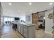 Open concept kitchen with gray cabinets, island and view to dining and living area with sliding barn door to bedroom at 7003 Eagle Dr, Nineveh, IN 46164