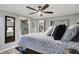 Bedroom with ceiling fan, neutral decor, and a view into a bathroom at 7003 Eagle Dr, Nineveh, IN 46164