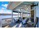 Cozy covered patio with lake view, stone fireplace, and comfortable seating, perfect for outdoor relaxation at 7003 Eagle Dr, Nineveh, IN 46164