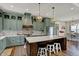 Bright kitchen with white countertops, wood floors, stainless appliances, island with seating and striking decorative lighting at 706 E 750 N, Lebanon, IN 46052