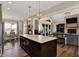 Open concept kitchen featuring dark wood island, quartz countertops, and decorative lighting at 706 E 750 N, Lebanon, IN 46052