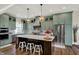 Modern kitchen featuring sage cabinets, a large island, stainless appliances, and elegant pendant lighting at 706 E 750 N, Lebanon, IN 46052