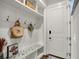 Mudroom area with storage, bench with floral cushion, hooks, and white wainscoting at 706 E 750 N, Lebanon, IN 46052