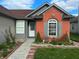 Beautiful home with a brick facade, gray siding, and a lush garden with flowers and greenery at 7201 Barnwell Pl, Indianapolis, IN 46217