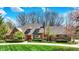 Charming brick home boasts a well-manicured lawn, mature trees, and a circular driveway at 7545 Chablis Cir, Indianapolis, IN 46278