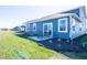 Backyard with patio seating, lush lawn, and a modern blue home exterior under a sunny sky at 7636 Big Bend Blvd, Camby, IN 46113