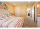 Cheerful bedroom with striped bedding, a white dresser, and an adjacent doorway view at 7636 Big Bend Blvd, Camby, IN 46113