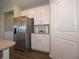 Partial view of a kitchen area with a stainless steel refrigerator and modern white cabinetry at 7636 Big Bend Blvd, Camby, IN 46113
