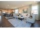Bright, open living room with modern furnishings, large windows, and an open concept connecting to the kitchen at 7636 Big Bend Blvd, Camby, IN 46113