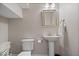 Powder room with white toilet and pedestal sink, neutral wall color and a framed mirror at 7638 Beekman Ter, Zionsville, IN 46077
