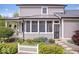 Exterior view of the home featuring a screened porch, a white picket fence, and professional landscaping at 7638 Beekman Ter, Zionsville, IN 46077