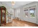 Light-filled foyer with hardwood floors, a grandfather clock, and a staircase with wooden railing at 7638 Beekman Ter, Zionsville, IN 46077