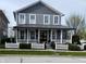 Charming two-story home featuring a welcoming front porch with a white picket fence and attractive landscaping at 7638 Beekman Ter, Zionsville, IN 46077