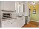 Bright kitchen features white cabinets, granite counters, stainless steel appliances, and subway tile backsplash at 7638 Beekman Ter, Zionsville, IN 46077