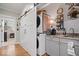 Laundry area with stacked washer/dryer and shelving with a sink and sliding barn door for privacy at 7638 Beekman Ter, Zionsville, IN 46077