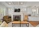 Cozy living room with a fireplace, hardwood floors, recessed lighting, and large windows with white shutters at 7638 Beekman Ter, Zionsville, IN 46077