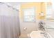 Bright bathroom with white wainscoting, framed mirror, shelves, and shower at 7735 E 50Th St, Indianapolis, IN 46226