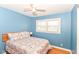 Bright bedroom with blue walls, ceiling fan, and comfortable patterned bedding at 7735 E 50Th St, Indianapolis, IN 46226