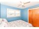 Bright bedroom with blue walls, ceiling fan, closet, and double windows at 7735 E 50Th St, Indianapolis, IN 46226