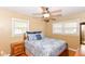 Bedroom with wood frame bed, ceiling fan, two windows, and hardwood floors at 7735 E 50Th St, Indianapolis, IN 46226