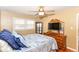 Bedroom with hardwood floors, ceiling fan, two windows, dresser and TV at 7735 E 50Th St, Indianapolis, IN 46226
