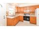 Efficient kitchen with solid-surface countertops, wood cabinetry, and a tiled backsplash at 7735 E 50Th St, Indianapolis, IN 46226