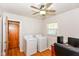 Laundry room with washer, dryer, desk, ceiling fan and wood floors at 7735 E 50Th St, Indianapolis, IN 46226