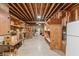 Unfinished basement featuring wooden shelving, exposed ceiling beams, and concrete flooring at 8027 Heyward Dr, Indianapolis, IN 46250