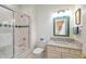 Bright bathroom with white tiled shower, vanity with marble countertop, and teal accents at 8027 Heyward Dr, Indianapolis, IN 46250