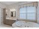 Relaxing bathroom with floral wallpaper, soaking tub, a neutral-toned vanity, and an accent light fixture at 8027 Heyward Dr, Indianapolis, IN 46250