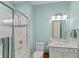 Bathroom features glass enclosed shower with blue accent tiles, white vanity, and bright lighting at 8027 Heyward Dr, Indianapolis, IN 46250