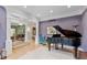 Open-concept living room with piano, hardwood floors, and detailed architectural columns at 8027 Heyward Dr, Indianapolis, IN 46250