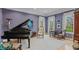 Formal living room with piano, plush rug, and large windows allowing natural light at 8027 Heyward Dr, Indianapolis, IN 46250