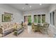 Light-filled sunroom with white trim, wicker furniture, and greenery views at 8027 Heyward Dr, Indianapolis, IN 46250